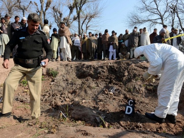 Security officials inspect the site of attack by militants in Peshawar on February 12, 2014